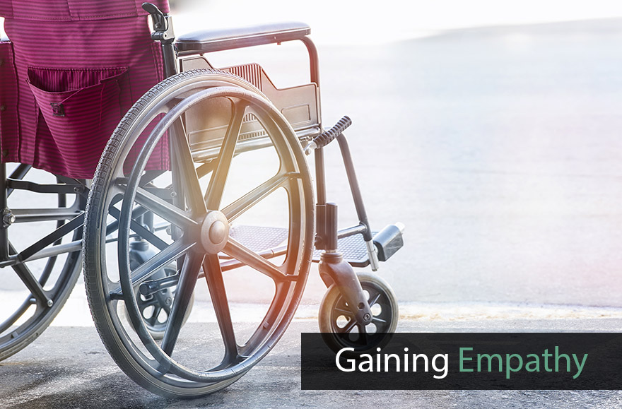 The photo depicts a wheelchair standing at an angle, on a light background. The photo is entitled 'Gaining empathy'.